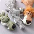 Three plush dog toys in knobbly fabric: a green wolf, a grey elephant and an orange lion