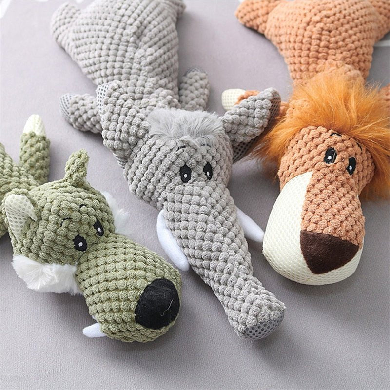 Three plush dog toys in knobbly fabric: a green wolf, a grey elephant and an orange lion