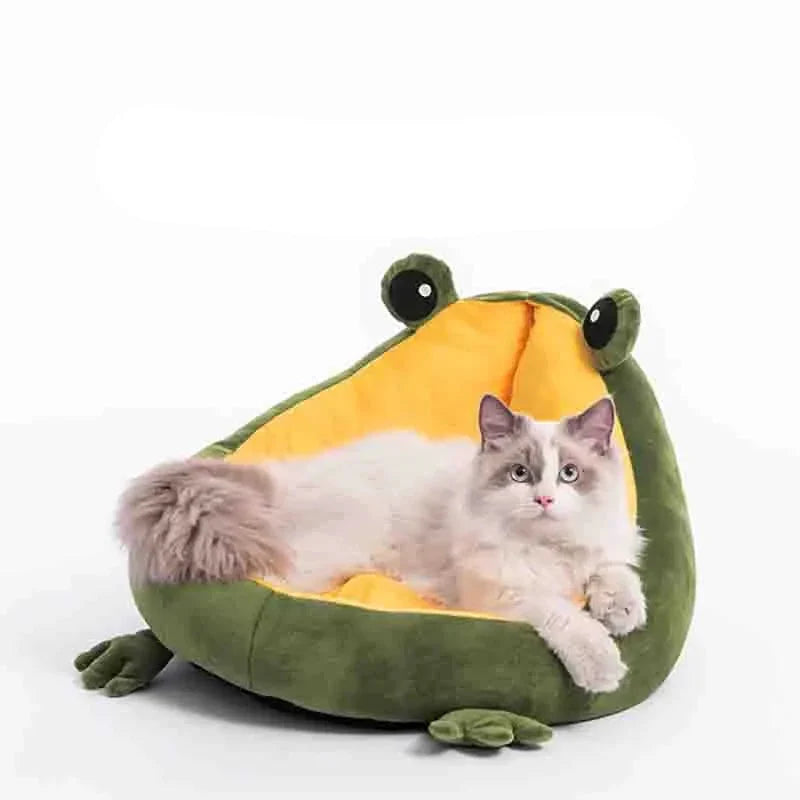 A cat lying across the yellow cushion of the frog-shaped bed