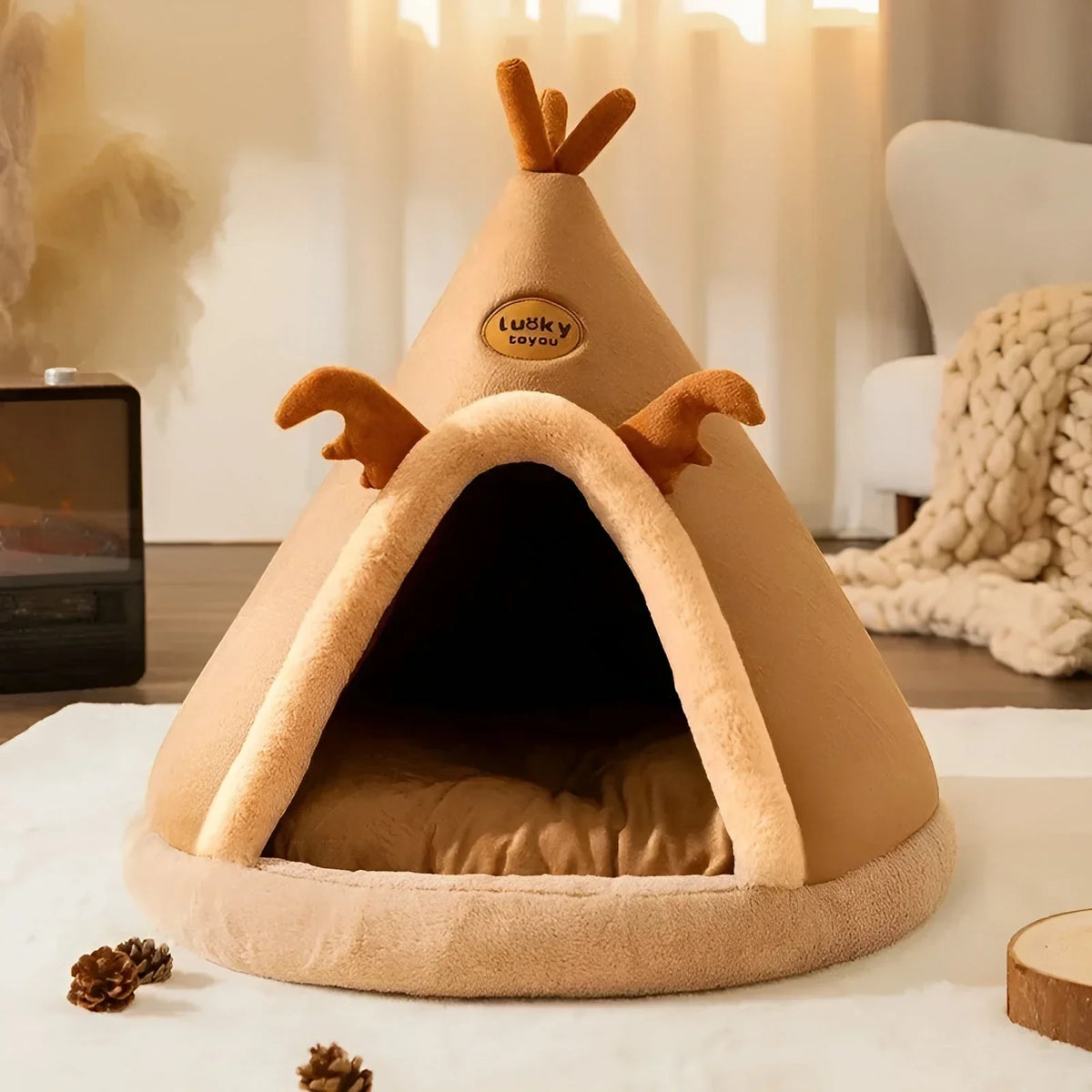 Caramel teepee cave cat bed with soft sprigs on the roof and a cushion inside
