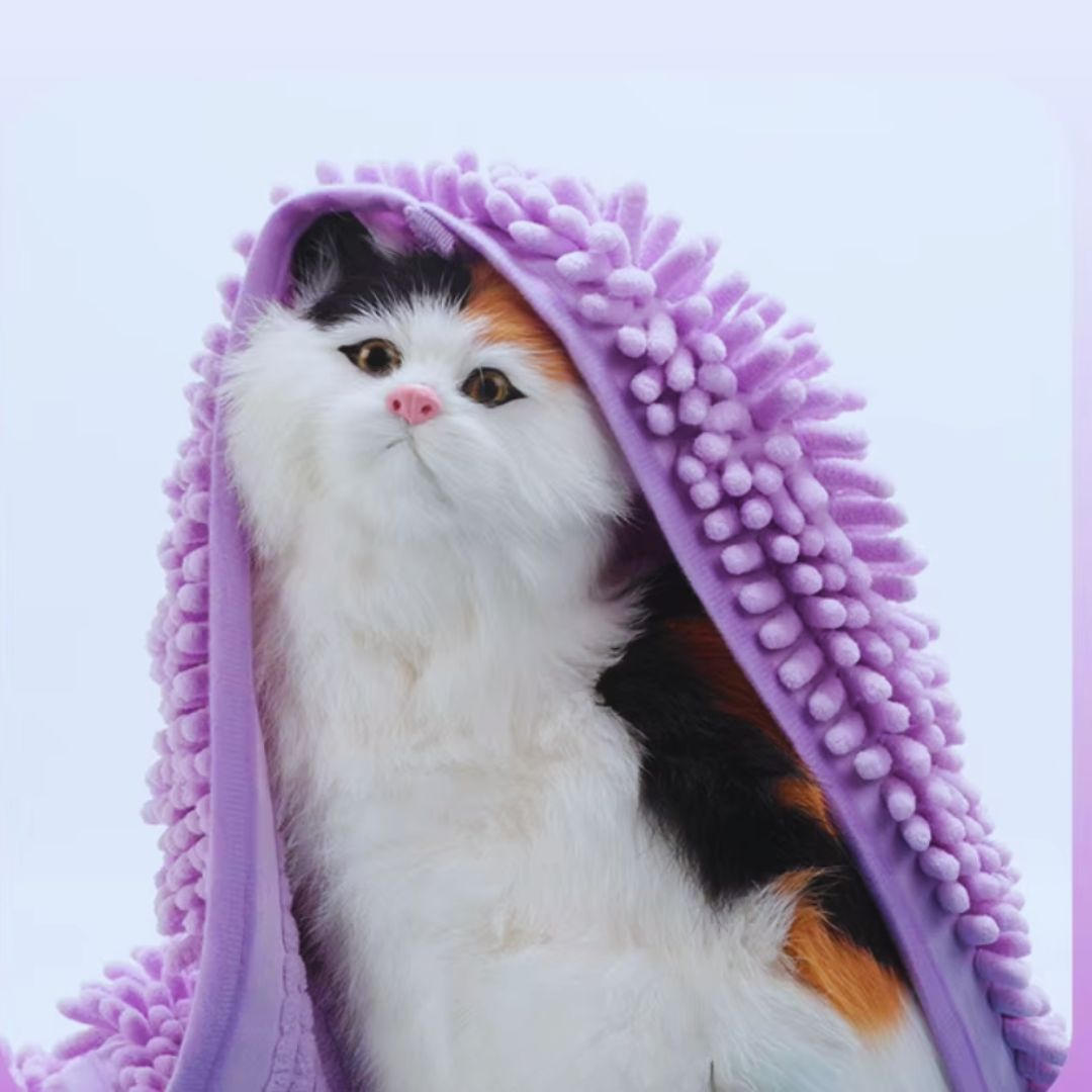 Lilac chenille pet towel draped over the head of a white, black and ginger cat