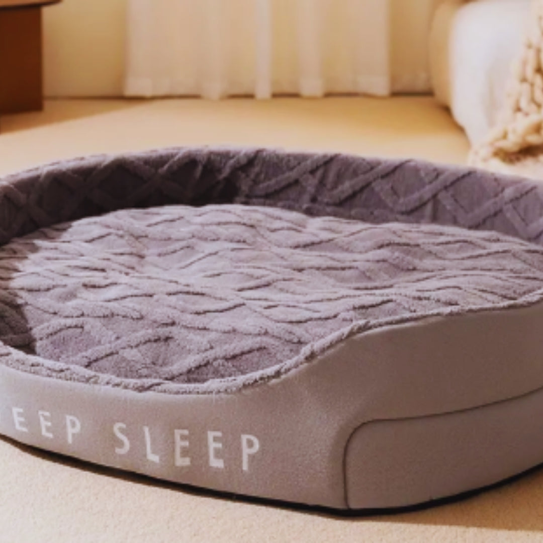 Lilac grey oval pet bed with a thick textured plush cushion inside the raised sides