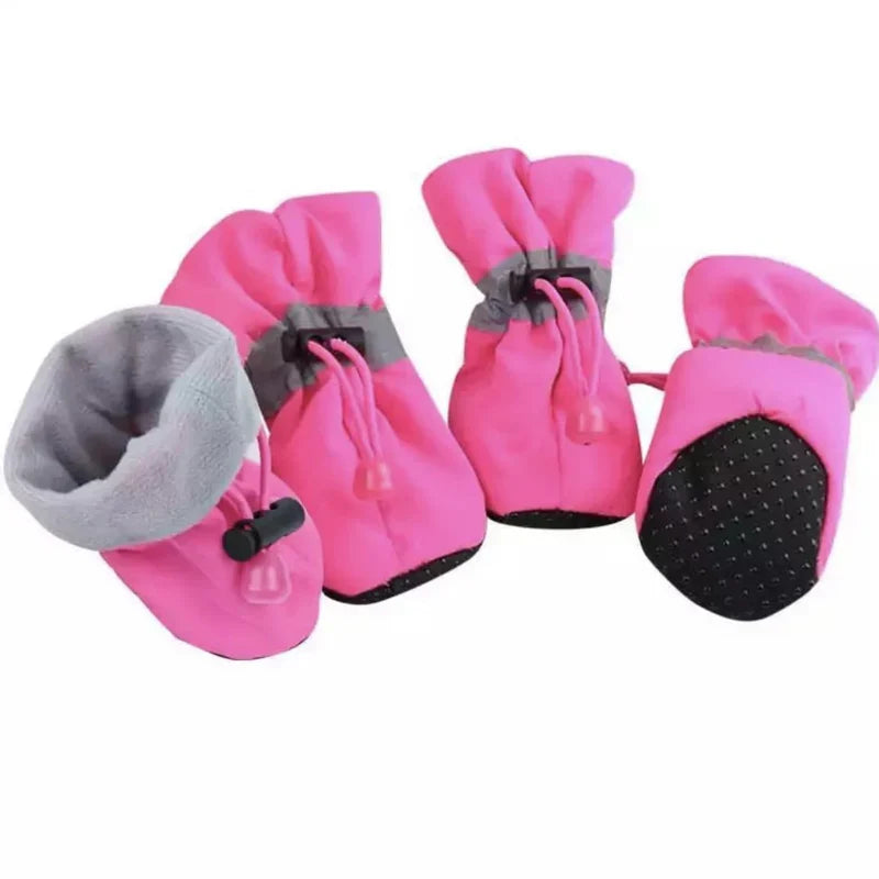 Four pink fleece-lined dog boots with grey reflective bands, drawstring toggles and a dotted non-slip sole