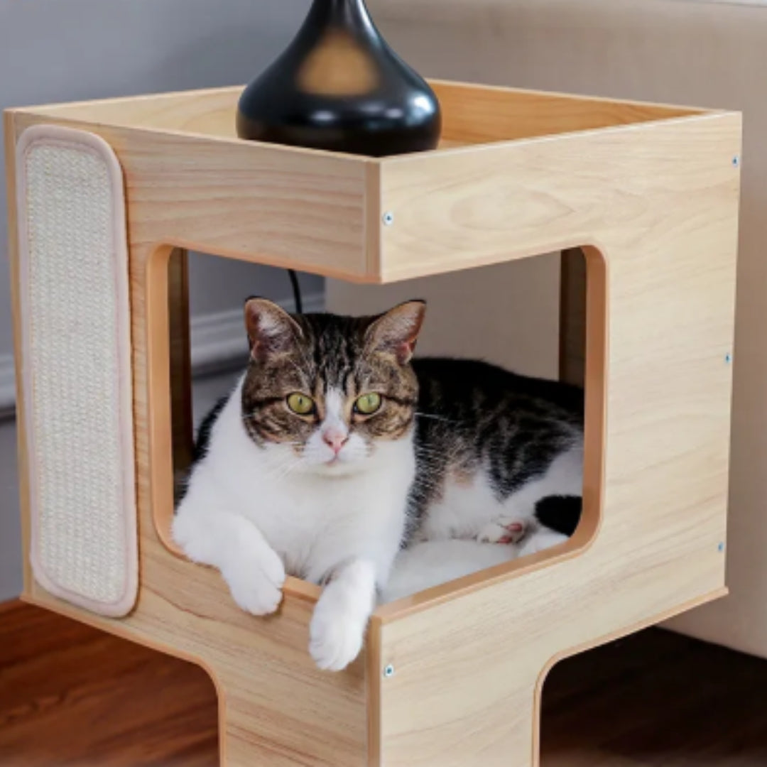 Tabby and white cat lying in the plush middle level of the wooden cat house, a sisal pad on the side panel