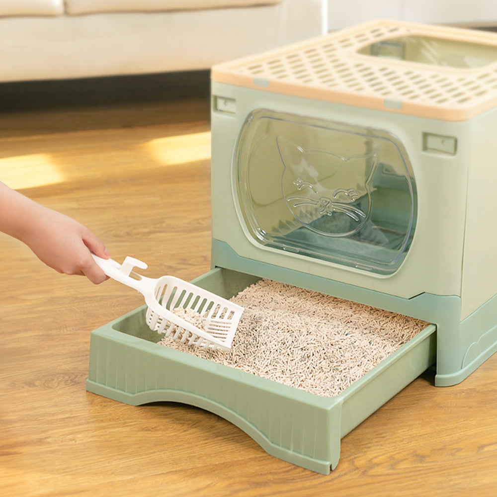 Scooping litter from the pulled-out drawer of the enclosed litter box