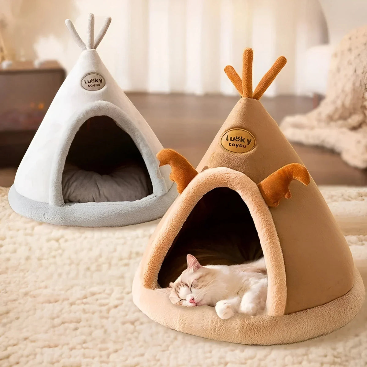 The light grey and the caramel teepee cave beds side by side, a cat asleep in the caramel one