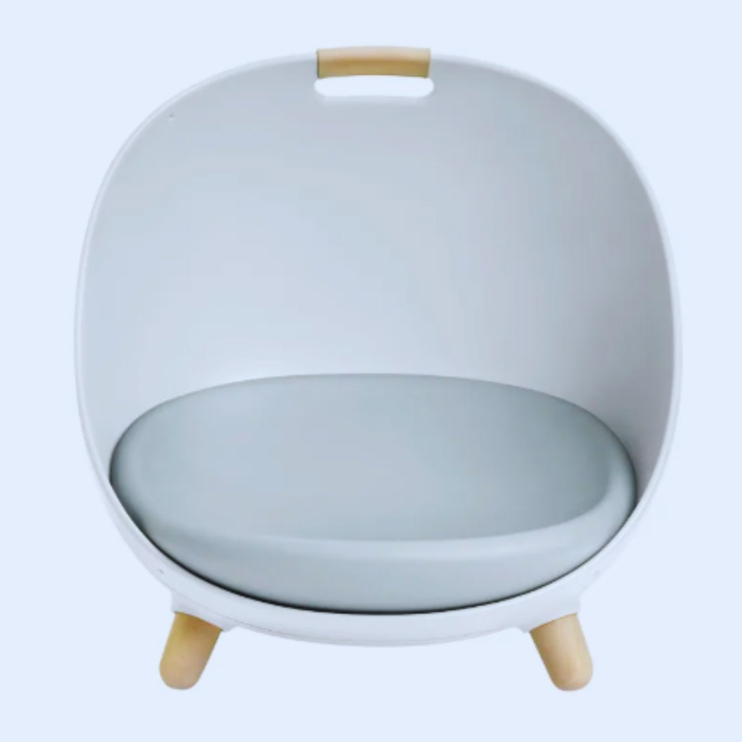 White egg-shaped cat bed with a grey cushion, wooden legs and a wooden carry grip