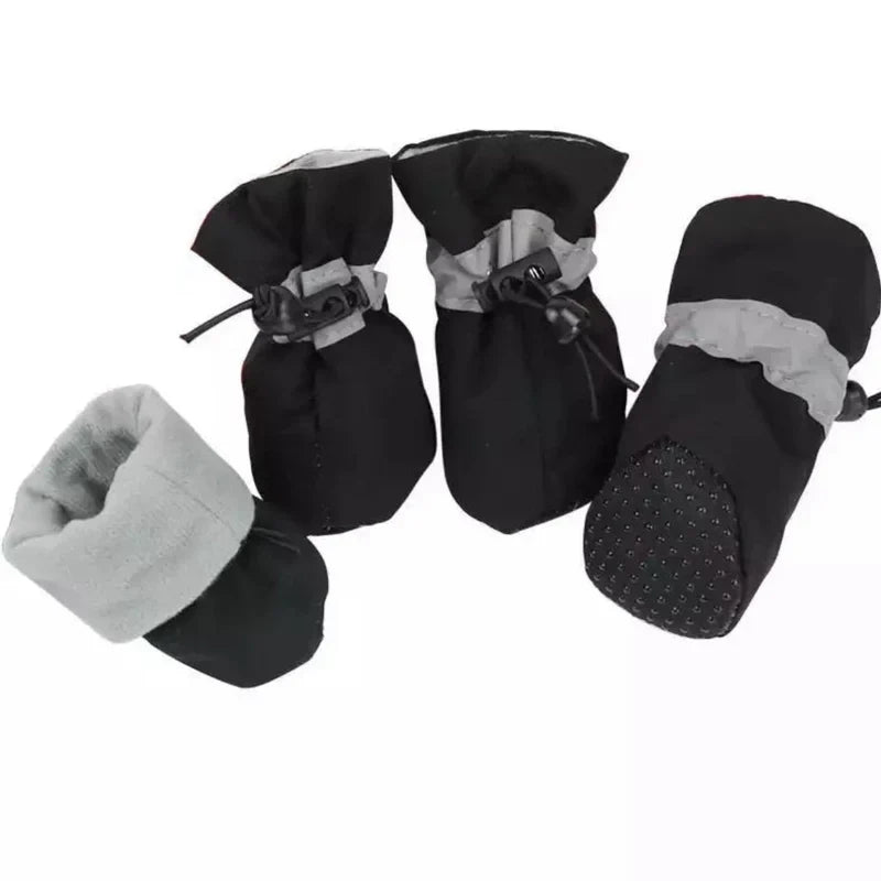 Four black fleece-lined dog boots with grey reflective bands, drawstring toggles and a dotted non-slip sole