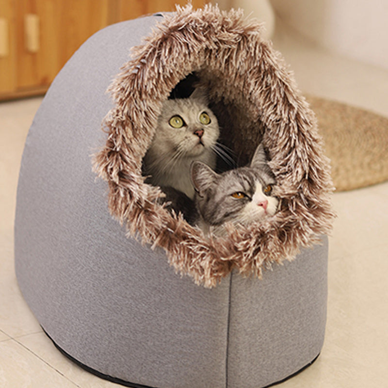 Two cats peeking out of the grey cave bed with a brown-tipped plush entrance