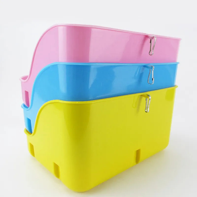 Pink, blue and yellow litter trays stacked, each with a small metal clip on the back wall