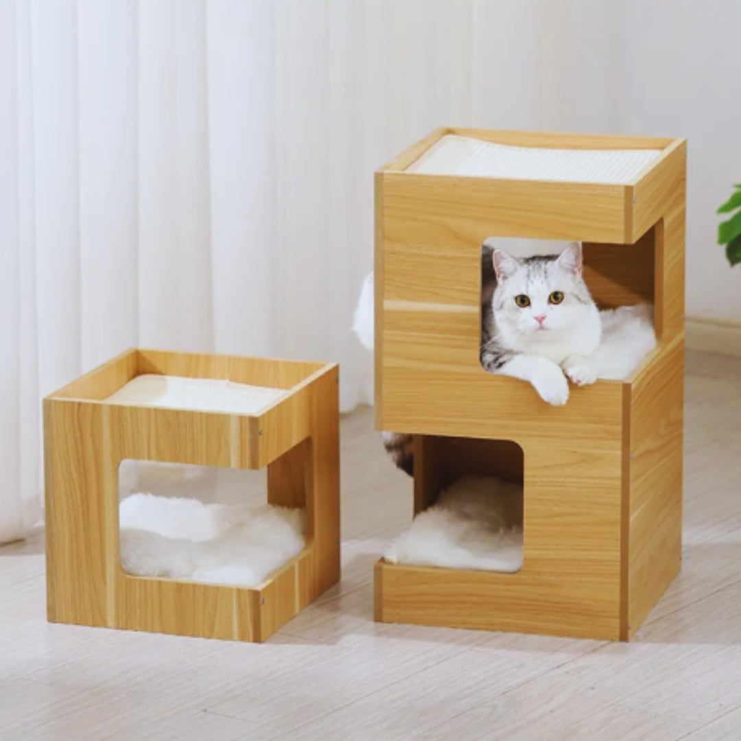 One-tier and two-tier wooden cat houses side by side, a white and grey cat in the two-tier house