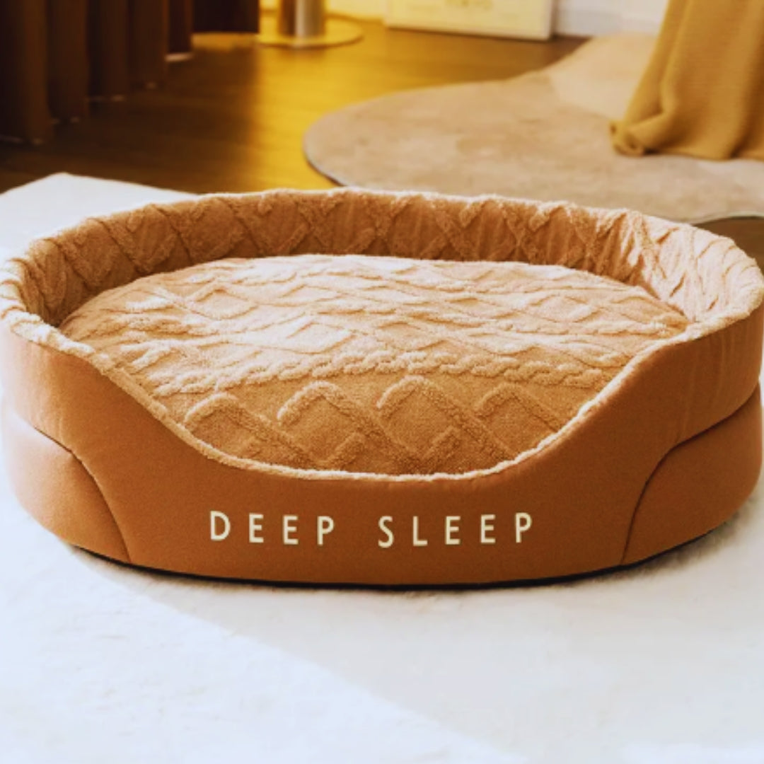 Caramel oval pet bed with a thick textured plush cushion inside the raised sides