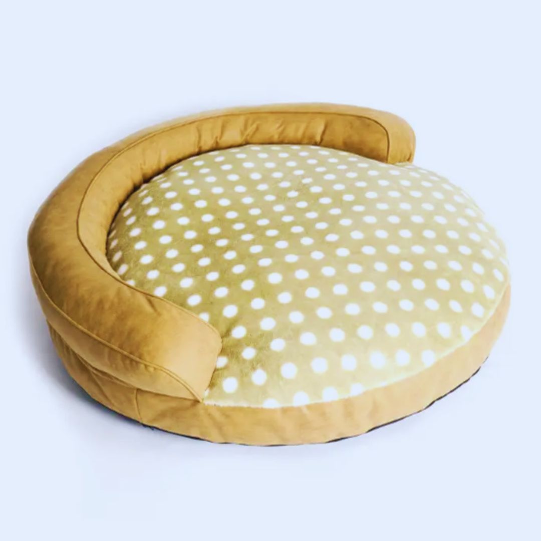 Round dog bed with a khaki leather-look bolster and a khaki seat with white dots