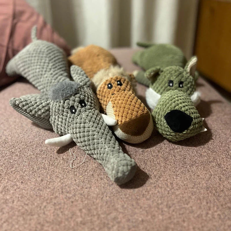 The three plush toys piled on a pink blanket