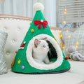 Green Christmas tree cave bed with a red felt bow and a white faux-fur entrance, a kitten looking out