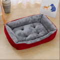 Red rectangular dog bed with ribbed outer sides and a tufted grey plush seat