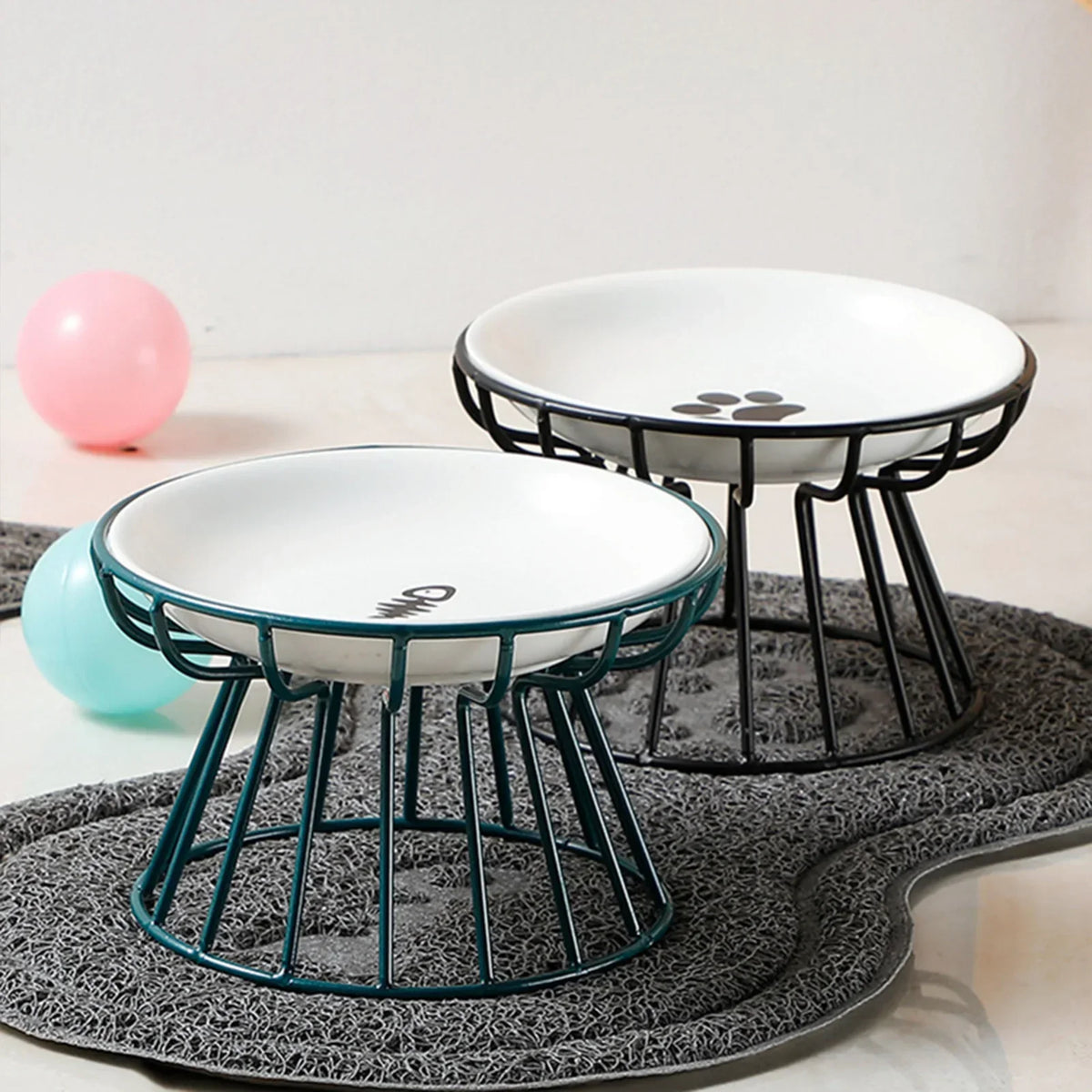 Two raised bowls on a mat, one in a green stand and one in a black stand