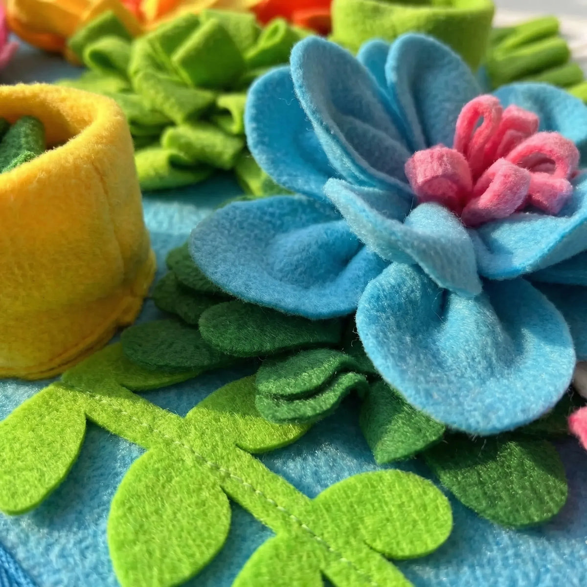 Close-up of the blue fabric flower and green leaves