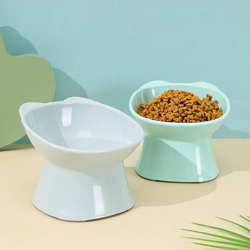 Two raised cat bowls, one filled with dry food, including a mint colour not sold here