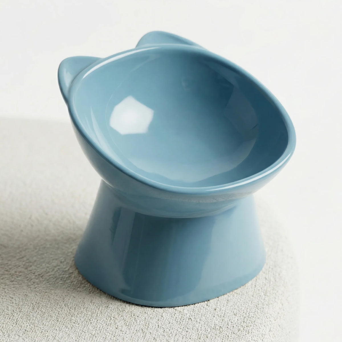 Blue raised cat bowl with a tilted opening and cat-ear rim