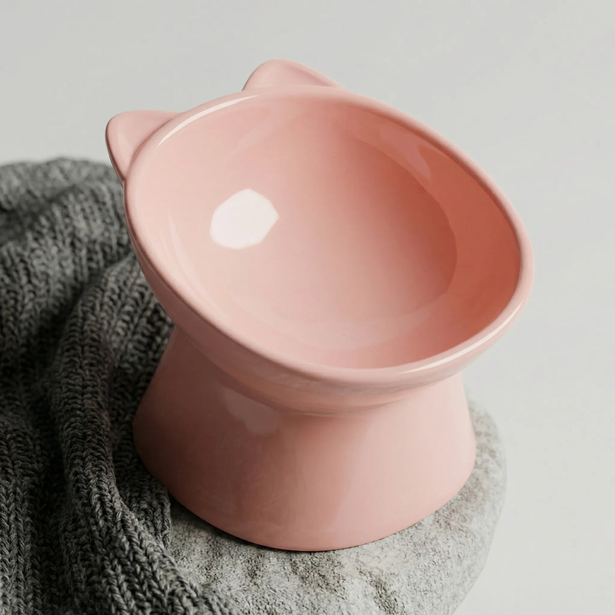 Pink raised cat bowl with a tilted opening and cat-ear rim