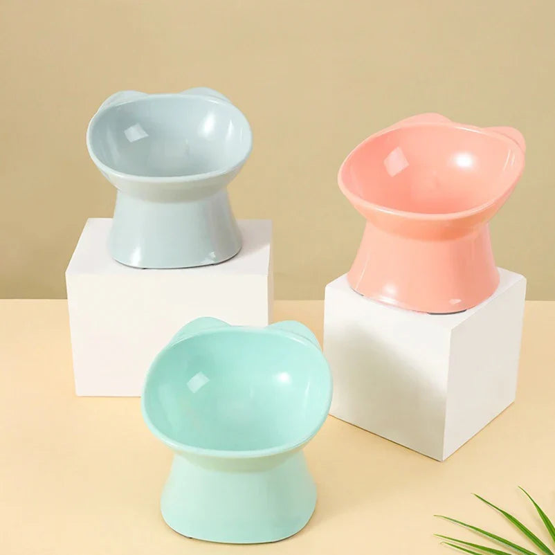 Three raised cat bowls on white blocks, including a mint colour not sold here