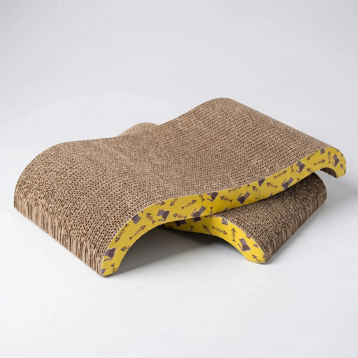 Two wave-shaped cardboard scratchers stacked on a grey floor