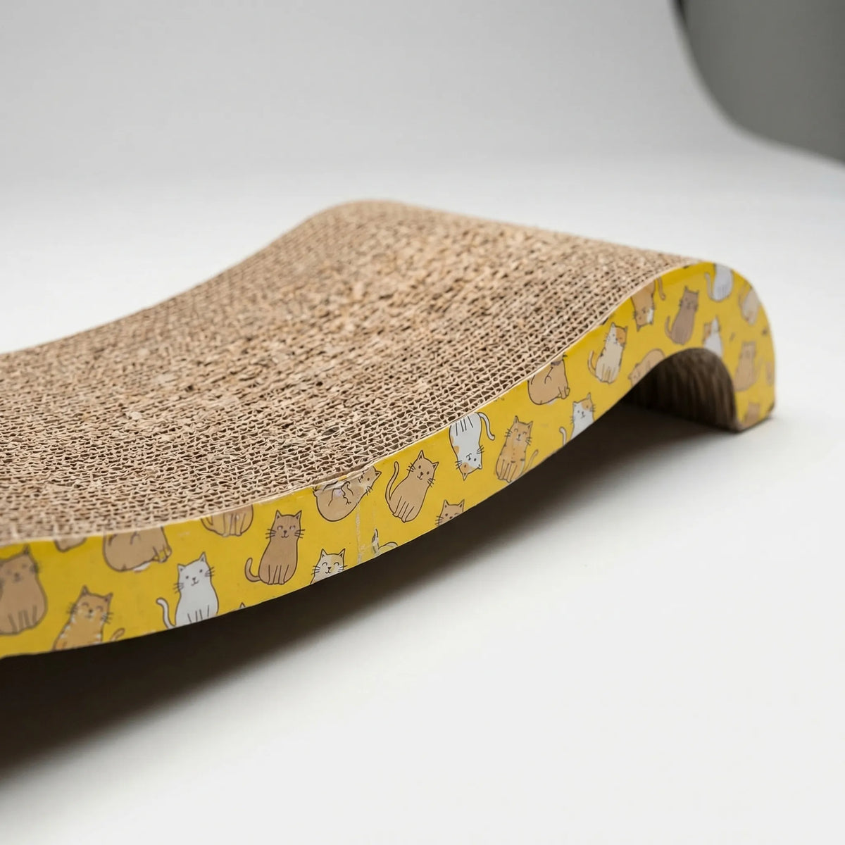 Side view of the wave-shaped scratcher with its yellow printed side