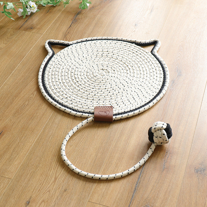 White coiled rope scratching mat with black flecks, a black edge and a rope ball toy