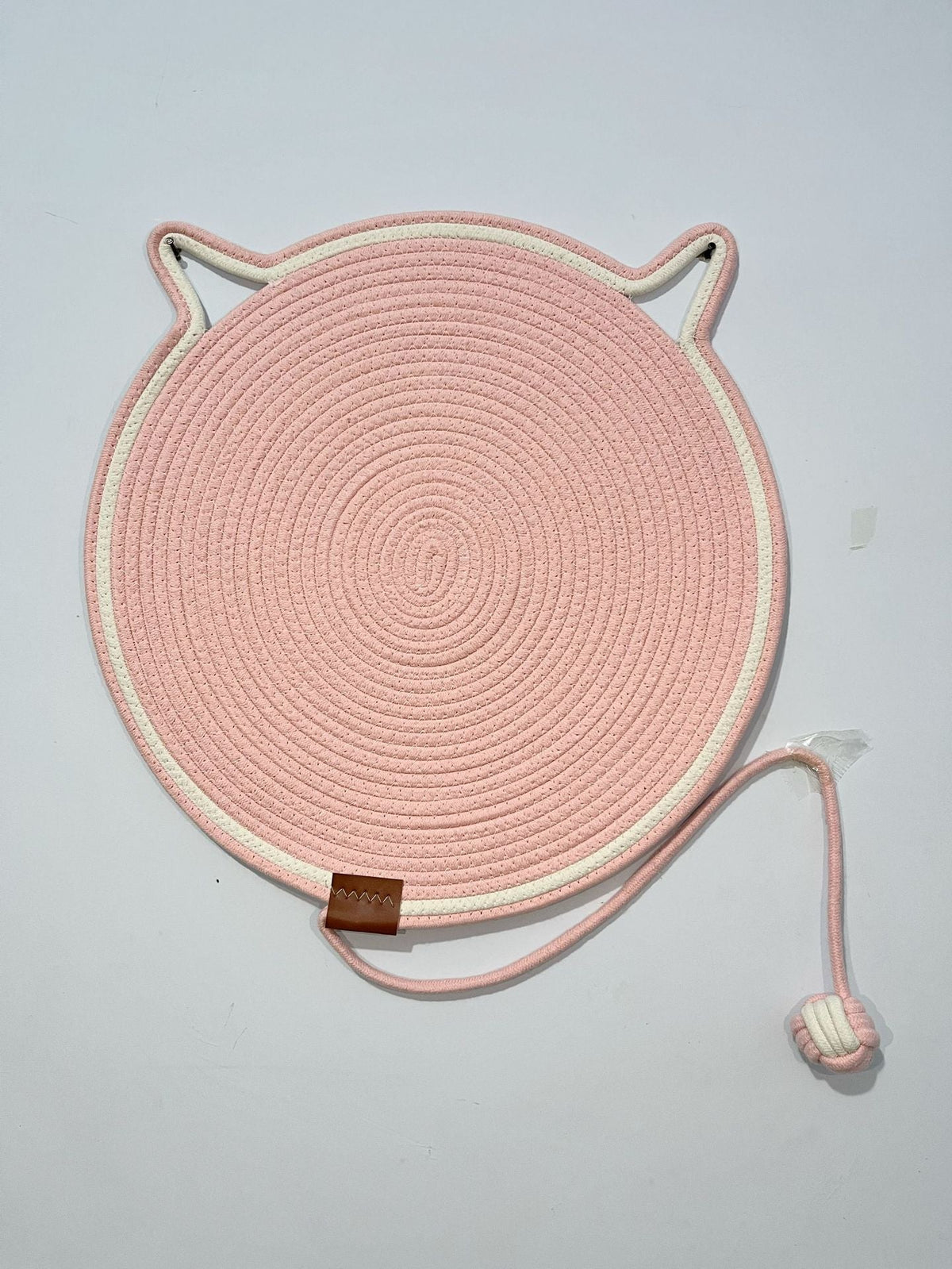 Pink coiled rope scratching mat with a white edge and a rope ball toy