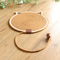 Caramel coiled rope scratching mat with a white edge and a rope ball toy