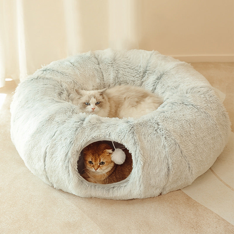 A white and grey cat lying in the middle of the light grey plush tunnel bed and a ginger cat looking out of the tunnel opening