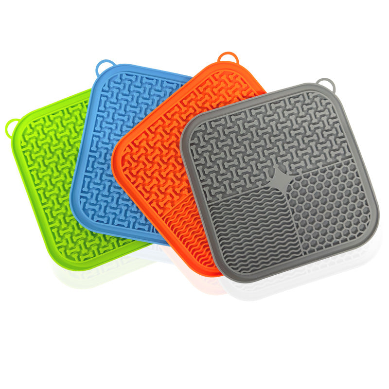 Four silicone lick mats in green, blue, orange and grey, fanned out