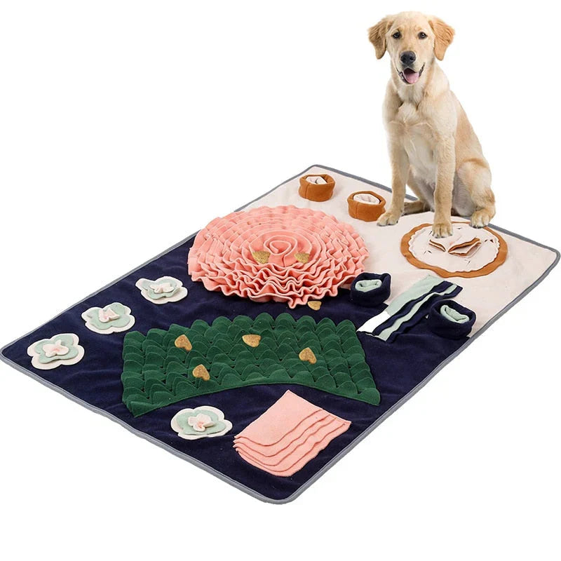 Pink Rose dog snuffle mat with a pink fleece rose, green leaf strips, felt flowers and cups, a golden dog sitting beside it