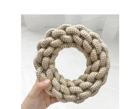 Braided cotton rope ring dog toy held in one hand