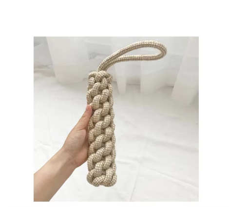 Thick braided cotton rope stick dog toy with a carrying loop, held in one hand