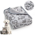 Folded grey paw print pet blanket with a grey bound edge, a white puppy and a tabby cat beside it