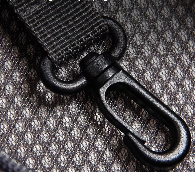 Close view of the black safety clip on its strap inside the sling