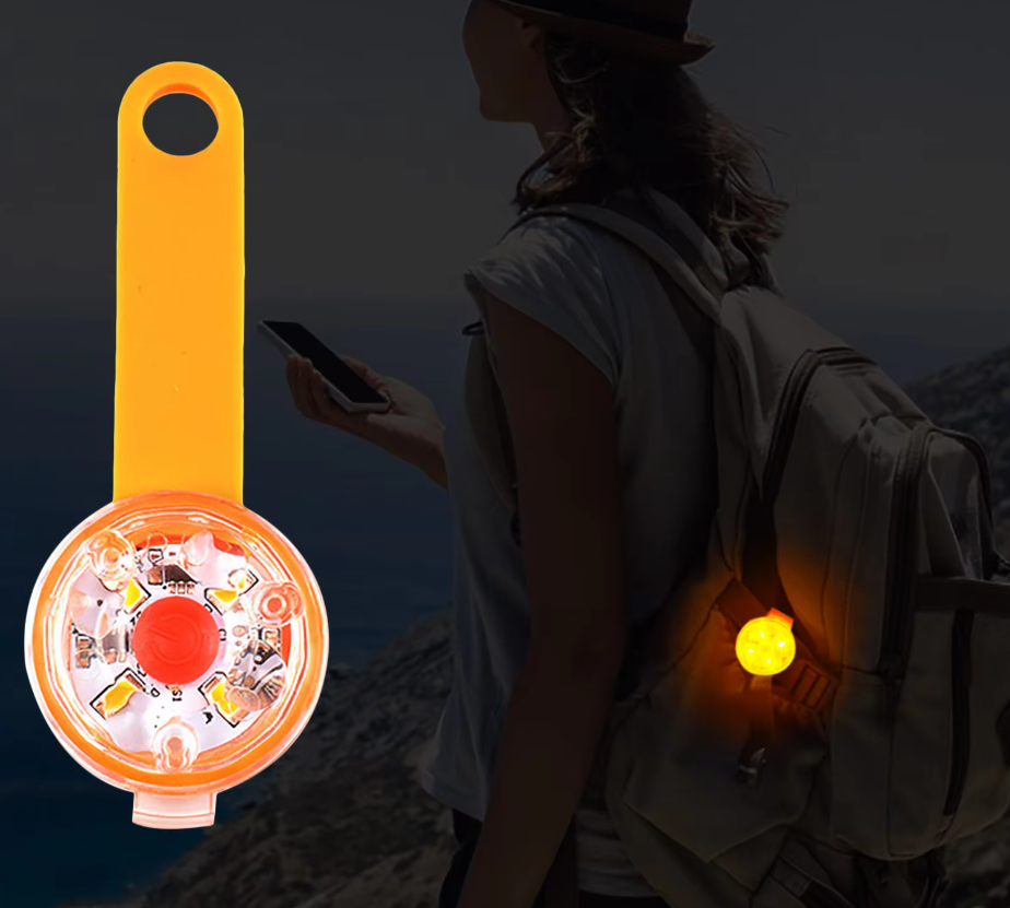 An LED light glowing on a backpack strap at night