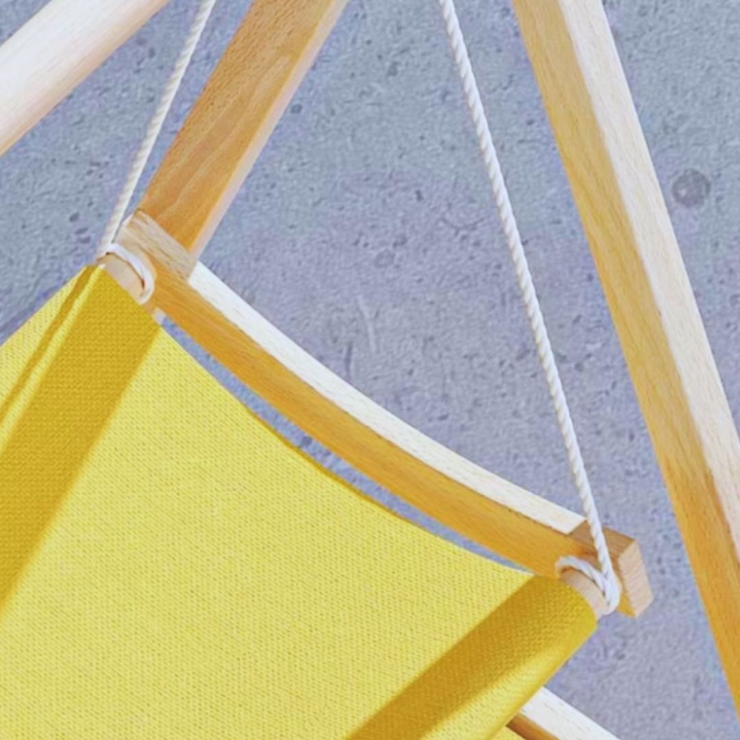 Close view of the rope knotted to the wooden end bar of the yellow swing hammock