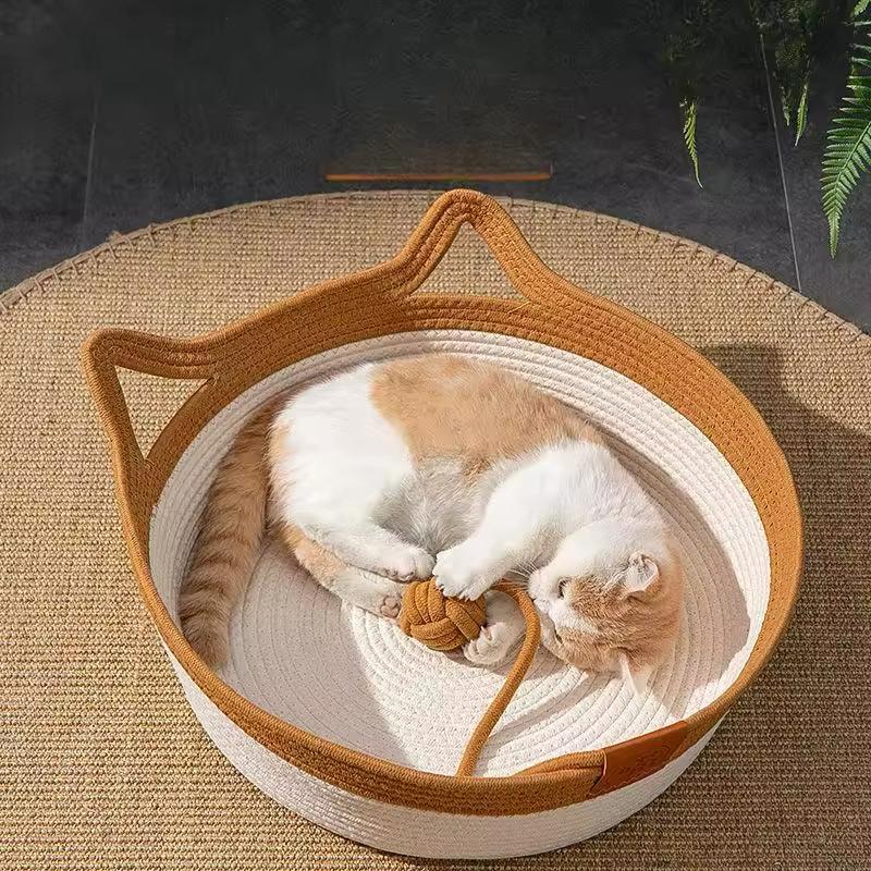 A cat asleep in the cotton rope basket bed with a khaki-brown band, on a round rug