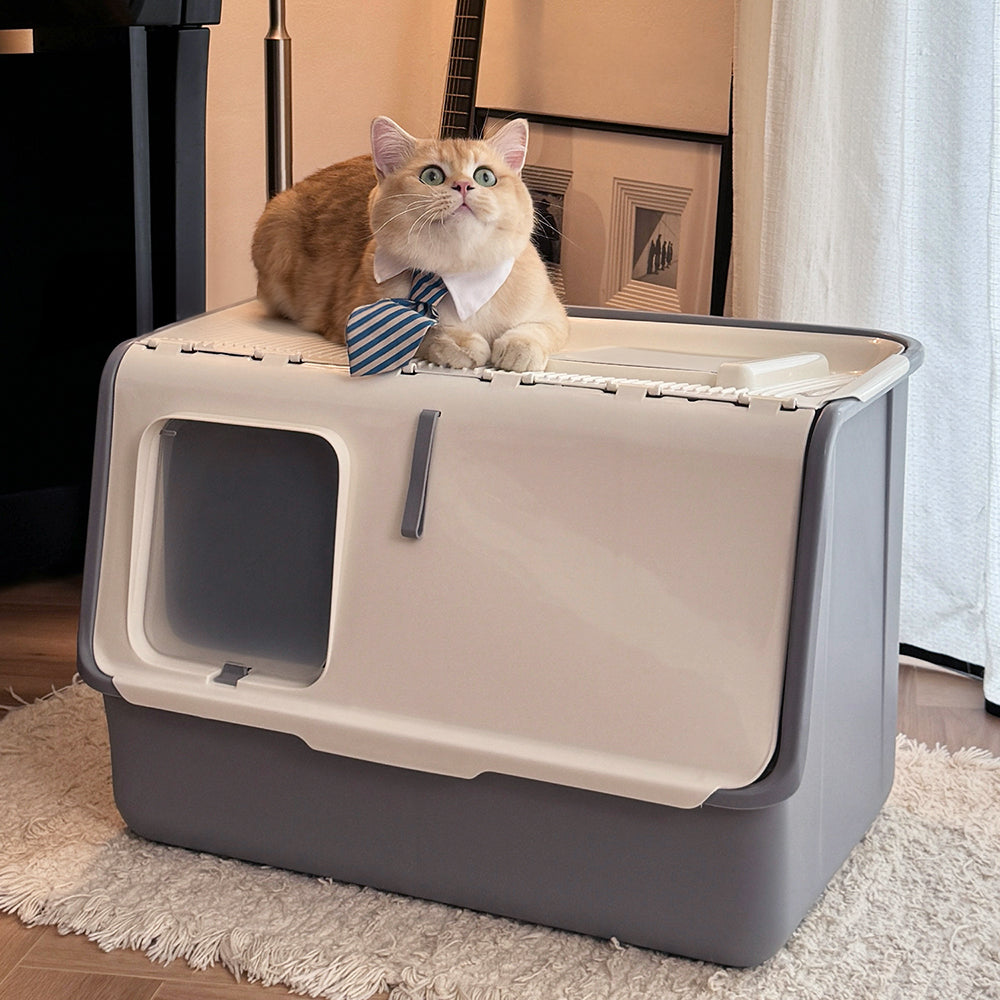 A ginger cat in a striped tie sitting on top of the white and grey hooded litter box