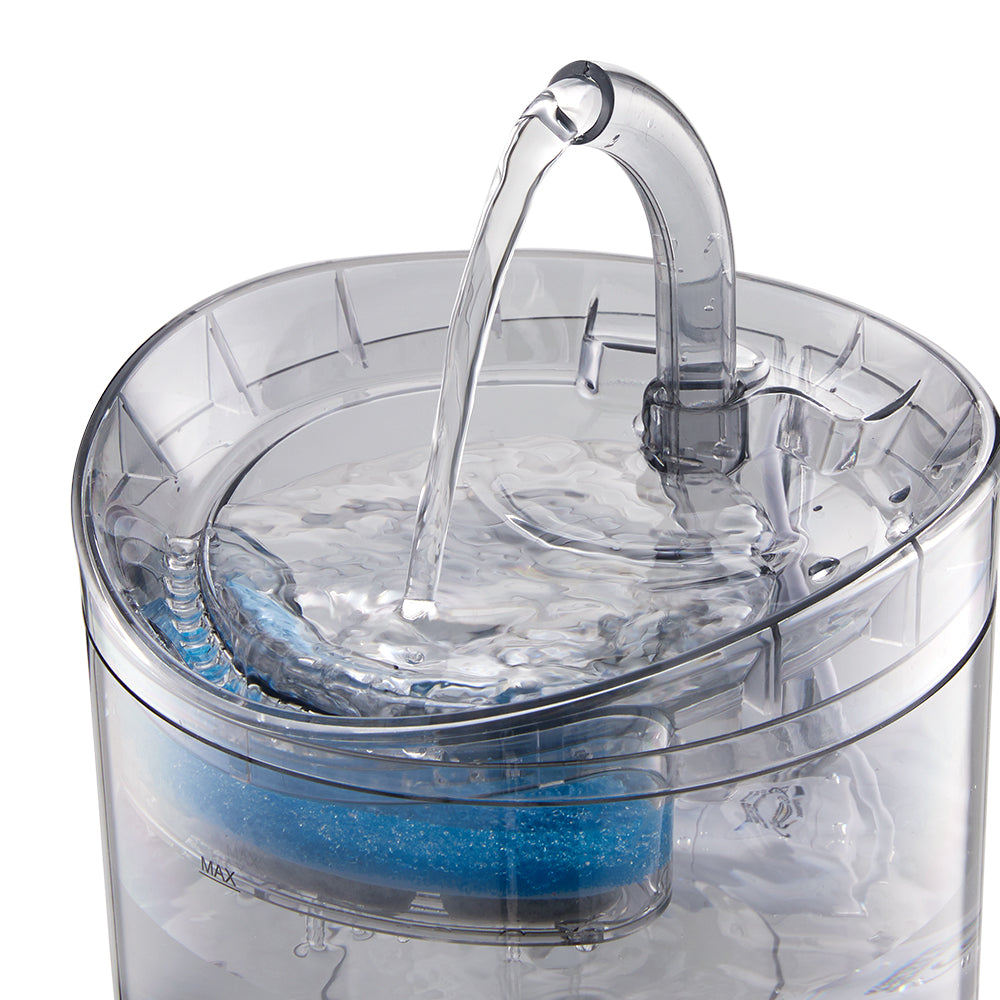 Top view of the arched spout pouring into the water tray of the clear fountain