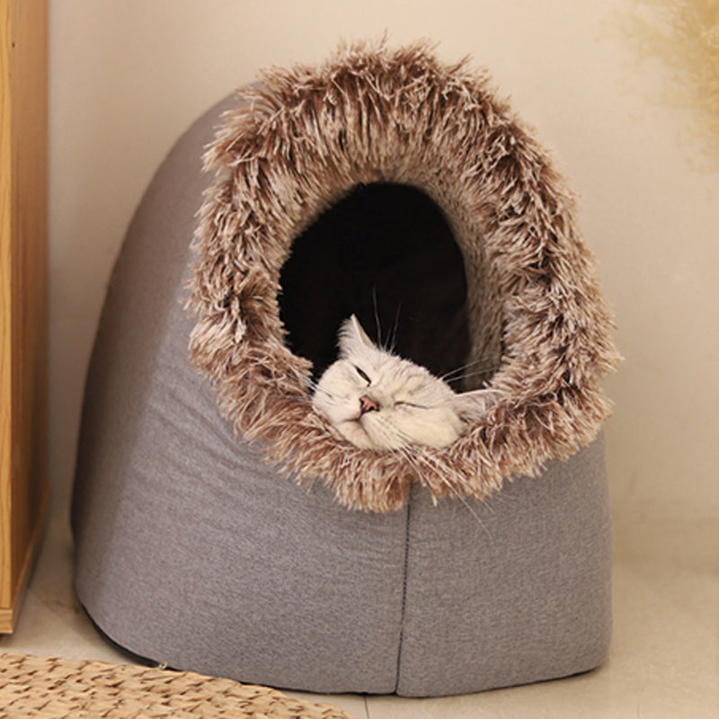 A cat asleep with its chin on the brown-tipped plush entrance of the grey cave bed