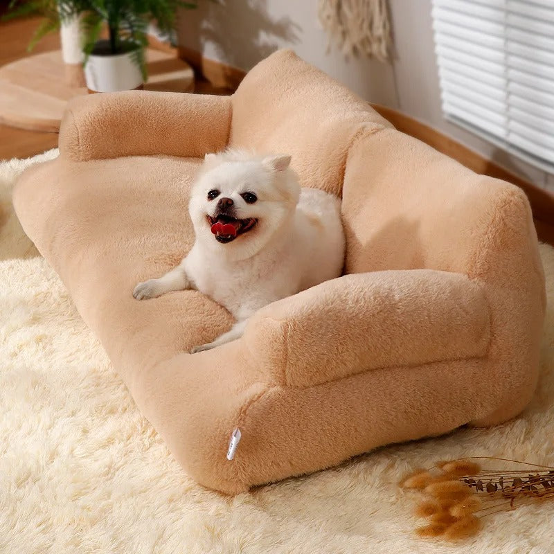 A small white dog lying on the camel plush dog sofa on a fluffy rug