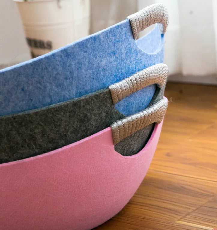 Three felt cat bed baskets stacked, blue, dark grey and pink, with rope-wrapped handles