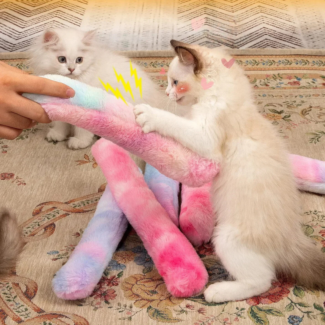 Two kittens playing with the tie-dye catnip kicker pillows on a rug