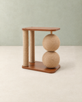 Cat scratching post with two sisal posts, two stacked sisal balls and a walnut-brown top perch, on a cream floor against a pale sage wall