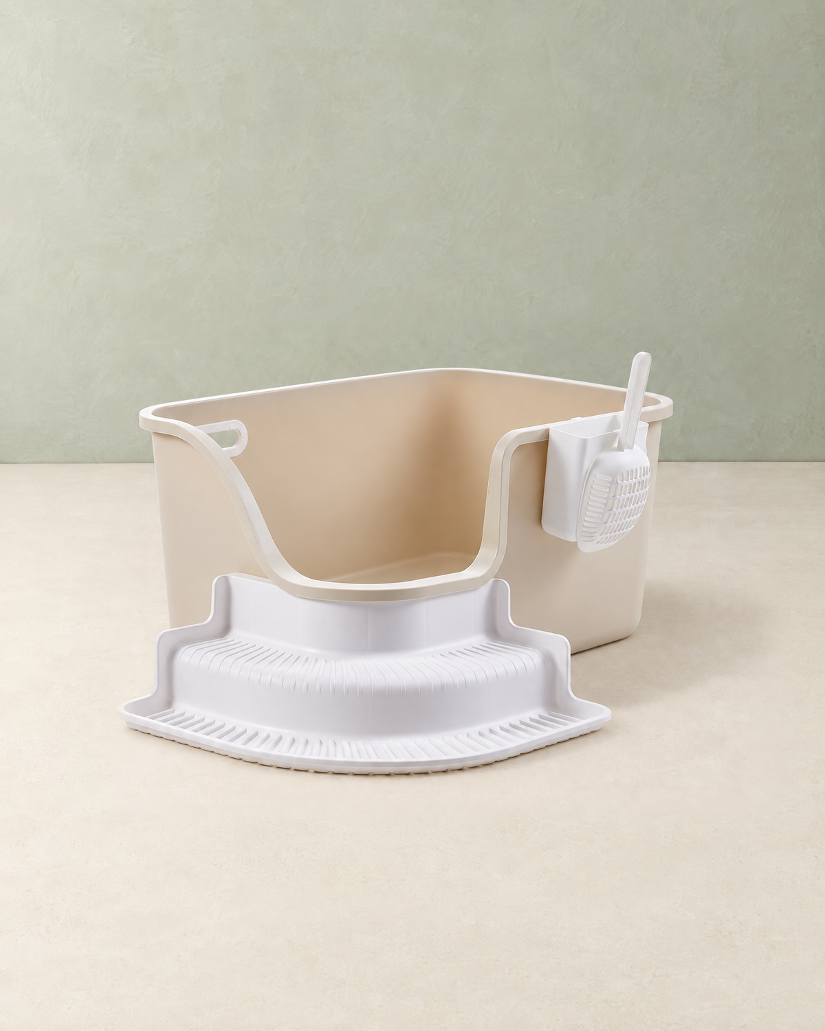 Beige open-top cat litter box with a white step and a scoop in its side holder, on a cream floor