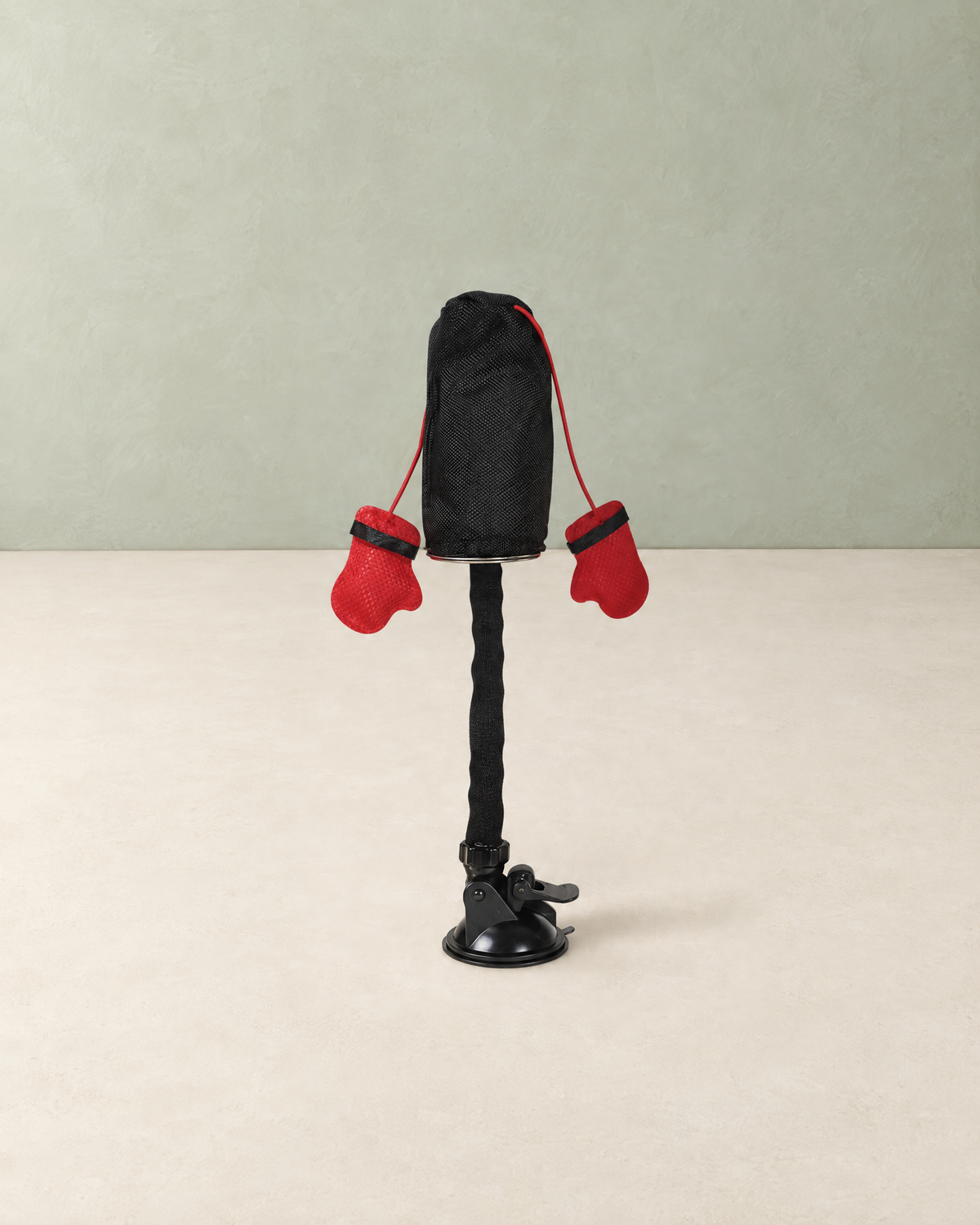 Cat punching bag toy with two red boxing gloves on a bendy stem and suction cup base, on a cream floor